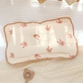 Dettaglio del cuscino in cotone per neonati con coniglietti rosa e bordo ricamato smerlato - Coniglio