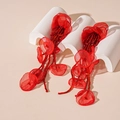 Detalle de pendientes de flores de encaje rojo con borlas de cuentas en soporte blanco - Rojo
