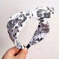 Black and white paisley headband featuring a twisted knot and elastic strap design - White