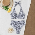 Flat lay of black and white paisley bikini set with a summer straw hat on a plush mat - Black