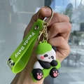 Detailed close-up of a panda keychain with a green panda baby wrist strap and gold ring - Panda Gen 3 - Style 04