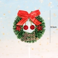 Detail of a 6.5cm green Christmas wreath cake topper with red bow and Merry Christmas sign - Red Star Red Berry Decor Wreath Style
