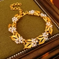 Detail of vintage gold bracelet with flower motifs, faux pearls, and sparkling crystals - Bracelet - Gold