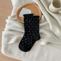 Cozy black wool socks with multi-colored polka dots in a warm home lifestyle setting - One Size / Black