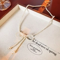 Elegante collana di perle stile francese con fiocco intrecciato e nappe di perle pendenti - Stile Perla Bianca