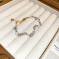 Detailed view of handmade beaded flower bracelet in purple and white inside a jewelry box - Style 50 / Purple