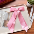 Close-up of pink satin bow hair clip with long streamers on an elegant display tray - Tender Pink 22