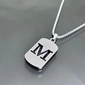 Macro view of silver titanium steel necklace featuring a hollow rectangular M letter pendant - M