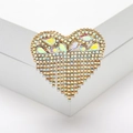 Dettaglio della spilla a cuore con nappe e strass arcobaleno AB su base dorata - Oro