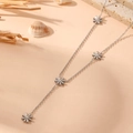 Silver Y-shaped stainless steel necklace with small flower pendants on a beach theme backdrop - Silver Daisy Necklace (H707)