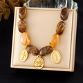 Vintage gold cross and Guadalupe medal necklace with amber marble beads on a gift box - Amber Irregular Beaded Religious Pendant Necklace (N4009)