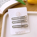 Three silver wavy Y2K metal hair clips on a white display card with floral background - Hollow Wavy Linear Style / Set of 3