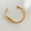 Bracciale rigido dorato minimalista con design a onde irregolari e finitura lucida - Bracciale Rigido Aperto Ondulato (A1048) / Oro