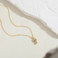 Detailaufnahme einer goldenen Katzen-Halskette mit funkelnden weißen Zirkonia-Steinen - Goldene Katze