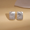 Close-up of silver-tone rectangular earrings with S-curve zircon on leather background - S-Shape Zirconia Geometric Studs / Silver