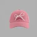 Close-up of pink cotton baseball cap featuring delicate white string bow embroidery - Bow Embroidered Baseball Cap Style / Pink