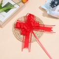 Dettaglio di fiocco rosso in organza su tappetino intrecciato per decorazione regali - Rosso