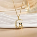 Close-up of golden owl necklace featuring blue gem eyes and a moon pendant with crystals - Gold Moon Owl/Blue Eyes Opal