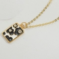 Macro view of gold plated necklace with black and white enamel flower pendant and small crystals - Black and White (XL3291-3)