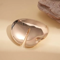 Detailed macro view of the golden irregular geometric metal brooch with a mirror finish - Gold