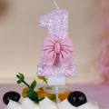 Close-up of pink number 1 glitter birthday candle with a cute decorative bow - Number 1