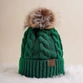 Close-up of dark green cable knit beanie with faux fur pom and leather logo patch - One Size / Dark Green
