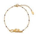 Détail du bracelet Mama en acier inoxydable doré avec pendentif couronne et perles - Série Café