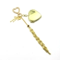 Detalle de relicario de corazón dorado con lazo metálico y borlas largas de cadena fina - Estilo Corazón Dorado