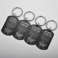 Detail of four black stainless steel dog tag keychains with engraved inspirational quotes - Keychain / Black