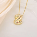 Macro detail of golden bubble letter Z pendant with multicolor zircons on satin - Letter Z