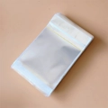 Bolsas de embalaje OPP transparentes autoadhesivas para joyas sobre fondo beige neutro - 10*18cm-Con Orificio de Suspensión-Doble Capa 90 Micrones (100 Piezas/Paquete)