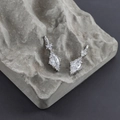 Vista macro di orecchini taglio marquise su pietra testurizzata e montatura argento - Base Argento - Zircone Trasparente