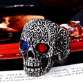 Detailed macro view of a vintage skull ring with red and blue gemstone eyes and floral carvings - Adjustable Open / Vintage Silver - Red and Blue Eyes