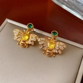 Detailed macro view of vintage bee earrings with gold finish and colorful zircons - Gold