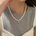 Collier élégant en perles blanches avec pendentif nœud argenté sur mannequin - Silver Bow Pearl Chain / Blanc