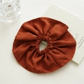 Detailed close-up of brown oversized fabric scrunchie with soft suede texture - Brown