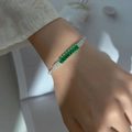 Silver-tone tennis bracelet featuring vibrant emerald-cut green zircons on wrist - Single Row Green