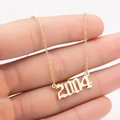 Detail view of gothic style 2004 birth year pendant on a gold stainless steel chain - 2004 / Gold