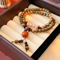 Ethnic woven bracelet with olive green wooden beads and red accents in jewelry box - Sandalwood Bodhi Tassel Style