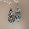 Detailed close-up of vintage silver earrings with blue teardrop stones and bead tassels - Blue Silver