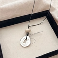 Irregular silver geometric pendant necklace with a beige bead on black cord strap - Silver