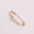 Golden waist pin fastener with four white pearls on textured beige paper backdrop - 3.8cm 4 Pearls Gold