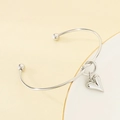 Detailansicht eines silbernen Herzanhänger-Armbands mit polierter Oberfläche und Endkugeln - Silber