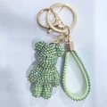 Detailed close-up of a green rhinestone bear keychain with matching crystal wrist strap - AB Light Green