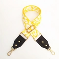 Macro detail of leopard pattern strap with adjustable buckles and gold metal clasps - Yellow