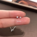 Macro shot of a 3mm round cubic zirconia silver stud earring held between fingertips - 4mm Zirconia Stud Earrings 1 Pair