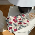 Detailed view of floral cotton makeup bag with red poppy print on a modern desk - Poppy