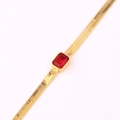 Detailed macro view of gold-plated snake bone chain featuring a red rectangular gemstone - Red Zirconia