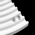 Detail shot of silver cross stud earrings with decorative floral backings on stand - Cross