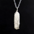 Macro detail of hand-wrapped tree of life silver wire on white hexagonal crystal pendant - White Crystal